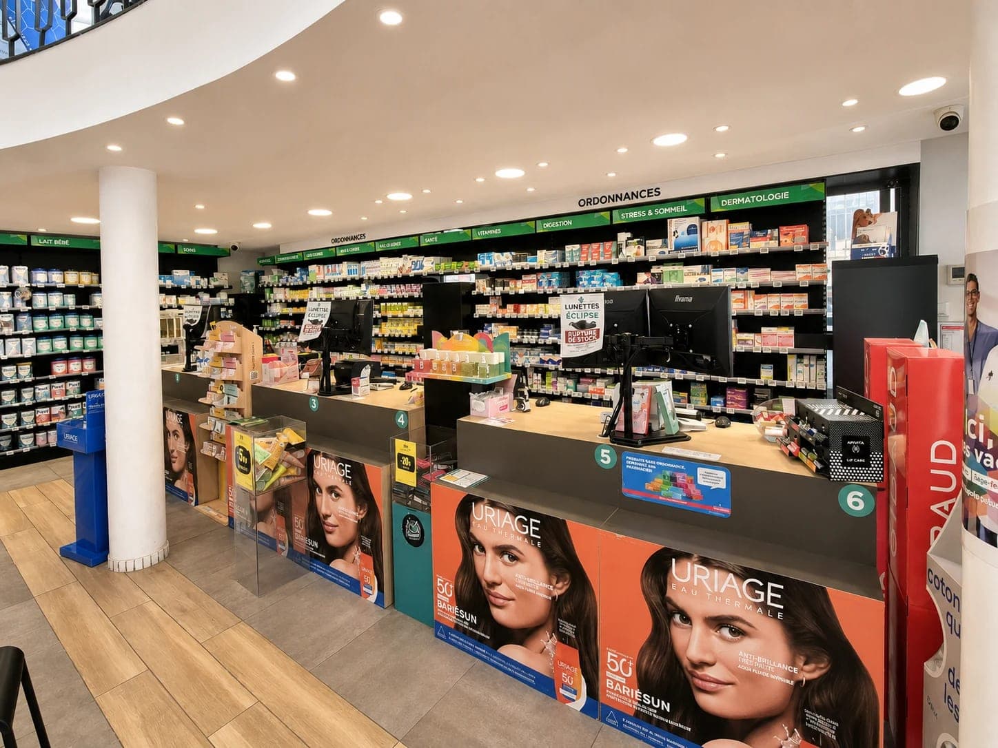 Comptoirs de la Pharmacie Saint-Martin à Hénin-Beaumont : espace ordonnances avec plusieurs postes de délivrance numérotés et rayonnages de médicaments conseil