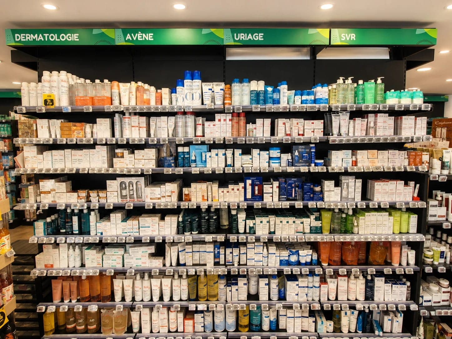 Mur dermatologie de la Pharmacie Saint-Martin à Hénin-Beaumont : rayonnages de soins dermo-cosmétiques Avène, Uriage et SVR